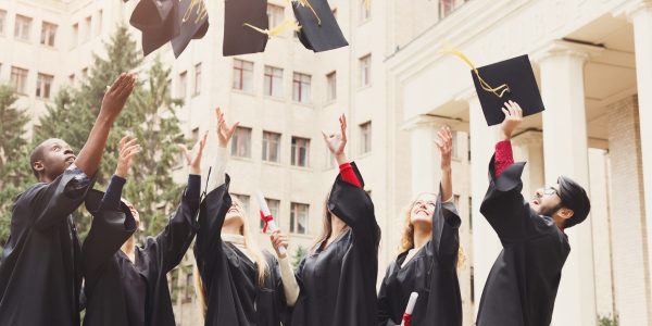 A group of graduates throwing graduation caps in the air BOA Mobilier de bureau professionnel